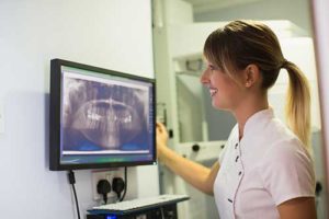 Dental assistant looking at panoramic x-rays in Austin, Texas